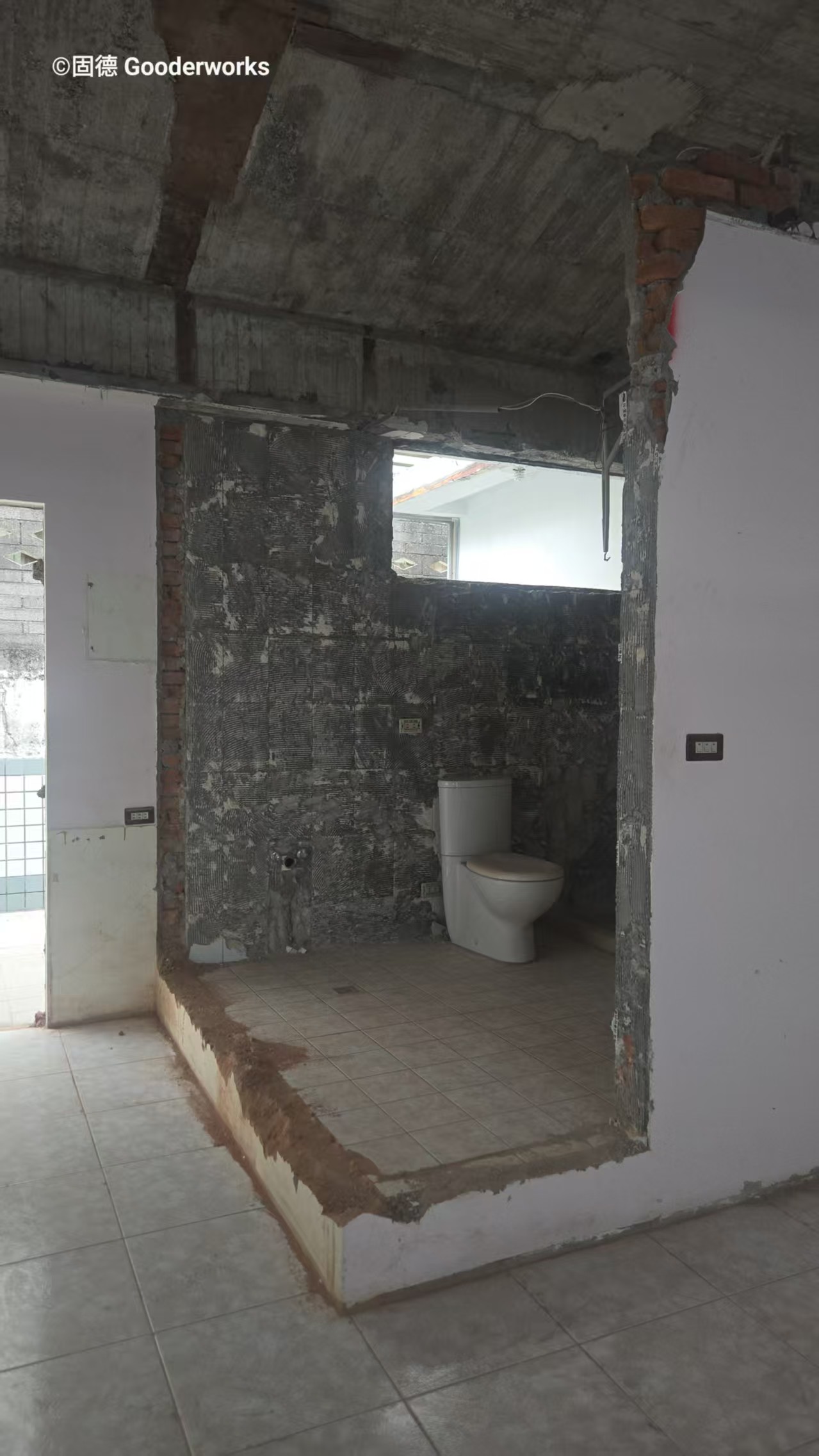 老屋翻修：浴室拆除後走廊視角，裸露結構與原始地坪