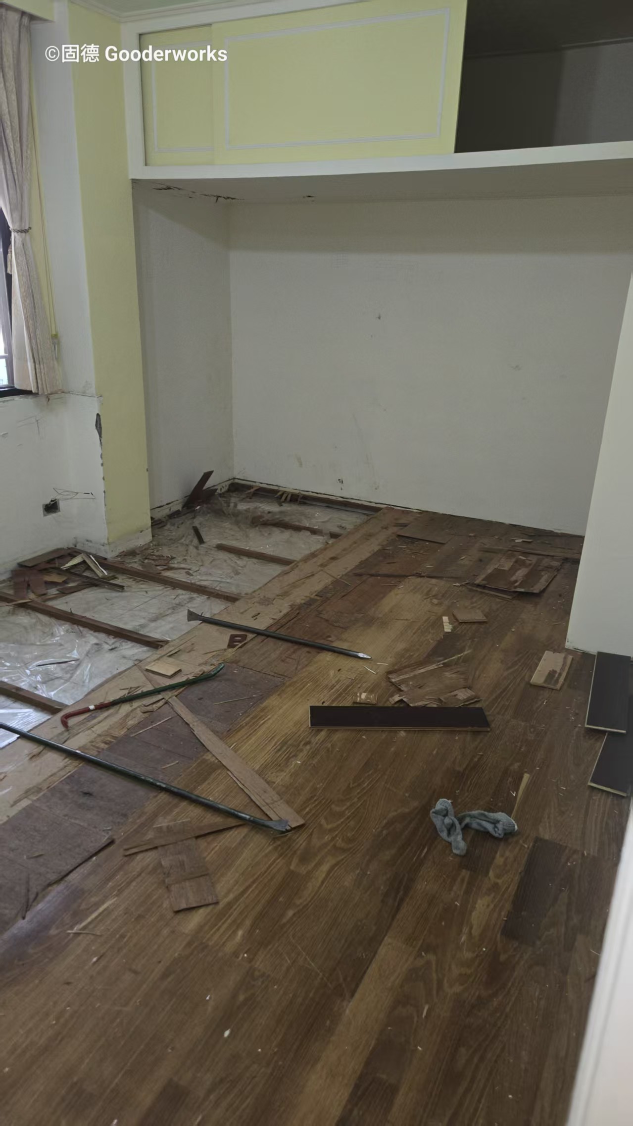 老屋翻修施工中拆除階段實景:木地板已拆除,露出原始結構,工具散落於施工現場,準備進入水電更新階段